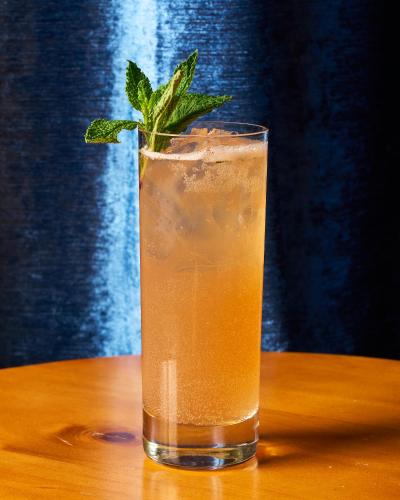 a drink with a sprig of mint sitting on a table at 42 Hotel Williamsburg in Brooklyn