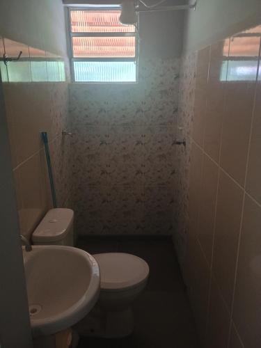 a bathroom with a white toilet and a sink at Chácara Cachoeira in Socorro
