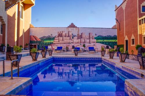 a pool in front of a building with a mural at Lamtounipalace in Ouarzazate
