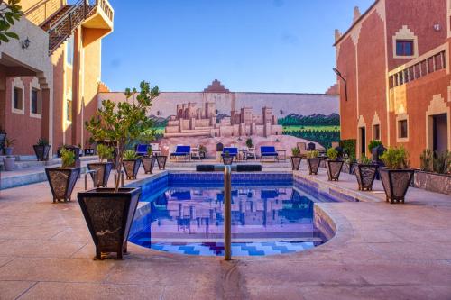 a pool in a courtyard with a building in the background at Lamtounipalace in Ouarzazate