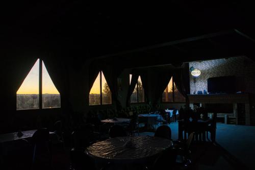 a dark room with tables and chairs and windows at Lamtounipalace in Ouarzazate