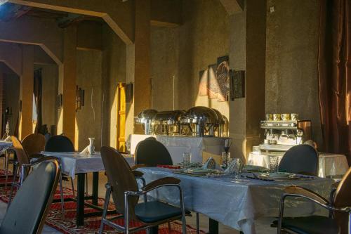 a dining room with tables and chairs in a building at Lamtounipalace in Ouarzazate