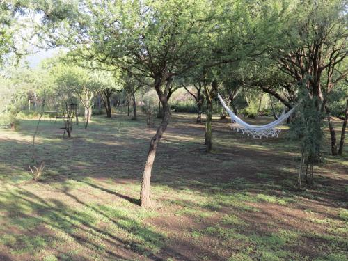 a hammock hanging from trees in a park at Arawi Cabaña in Merlo
