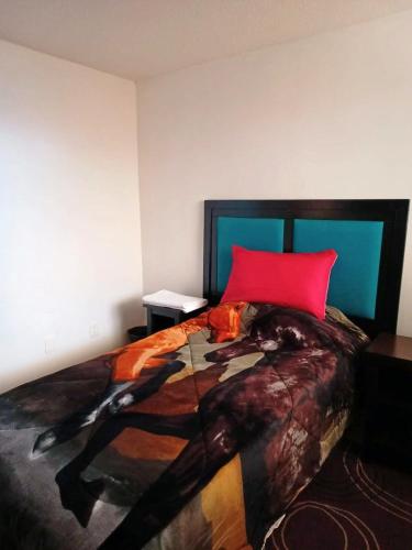 a bedroom with a large bed with a red pillow at Departamento completo en Real Granada in Santa Cruz Tecamac