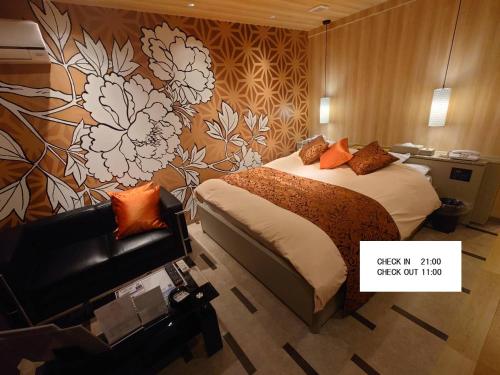 a hotel room with a bed and a couch at ホテル継kei男塾ホテルグループ in Himeji