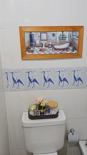 a bathroom with a toilet with a mirror on the wall at Hotel Boutique Watungasta in El Puesto
