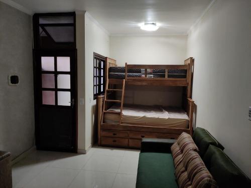 a living room with two bunk beds and a couch at Apto Chocolate Maranduba Ubatuba in Ubatuba