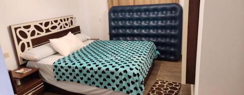 a bedroom with a bed with a black and white bedspread at Paradise Ras Sudr Chalet in Ras Sedr