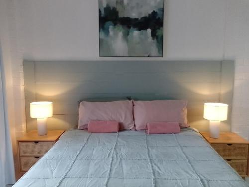 a bedroom with a bed with two lamps on it at 1 queen bed private bathroom own entrance in Long Jetty