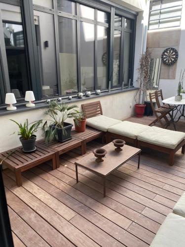 eine Terrasse mit Bänken und Topfpflanzen in einem Gebäude in der Unterkunft Welcome in Montpellier