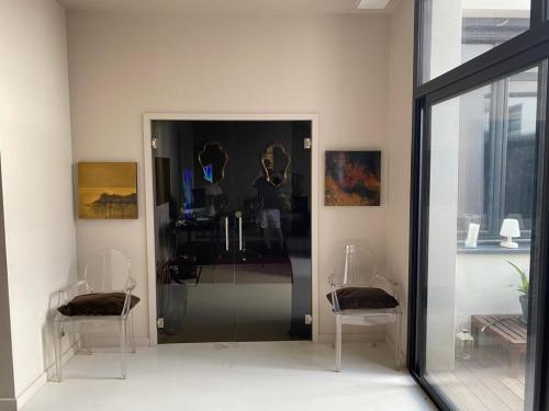 ein Zimmer mit zwei Stühlen und einer Glastür in der Unterkunft Welcome in Montpellier