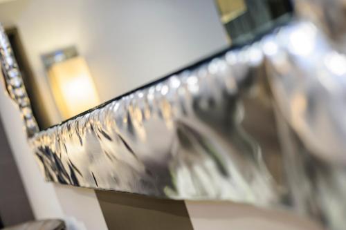 a mirror hanging on a wall next to a couch at The Hide London in Hendon