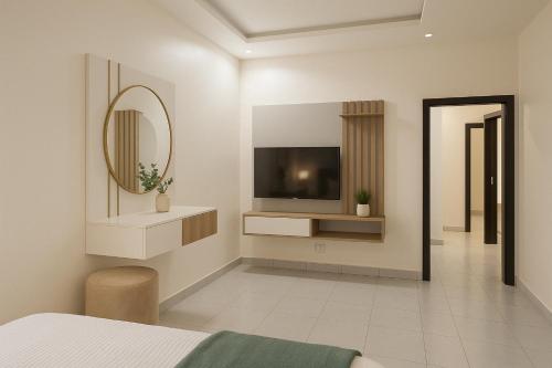 a bedroom with a tv on the wall and a mirror at Fully Furnished Luxurious 4 Bedroom Apartment in Lekki