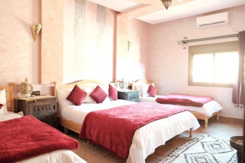 a bedroom with two beds and a window at Hôtel Bia Besta in Boumalne