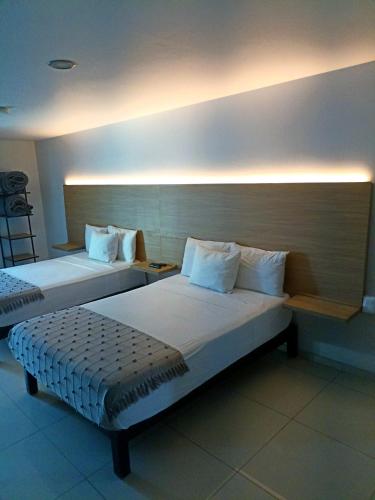 two beds in a hotel room with at Hotel Casa Galeana Centro con Estacionamiento Privado in Aguascalientes
