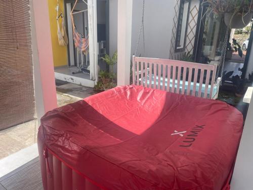 a red cover sitting on the porch of a house at Villa Bougainvilla in Anse-Bertrand