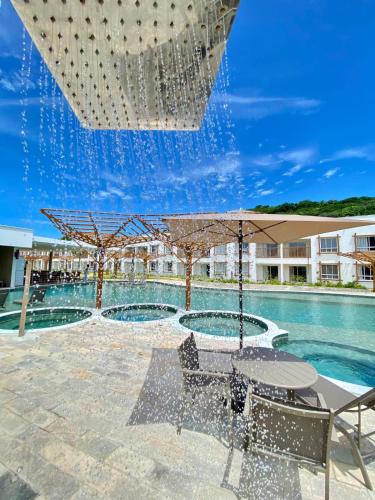 a patio with a table and an umbrella next to a pool at Pipa Privilege Ocean in Pipa