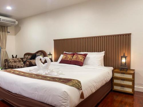 a bedroom with a large bed with a swan on it at Antique Thai in 1800s style Nimman in Chiang Mai