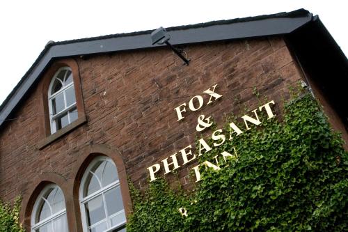un panneau sur le côté d'un bâtiment en briques dans l'établissement Fox and Pheasant Inn, à Armathwaite