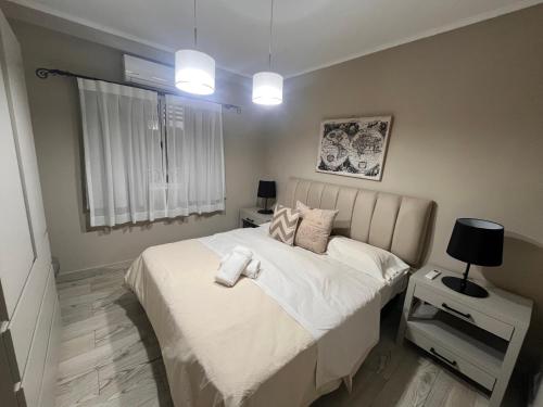 a bedroom with a bed with white sheets and a window at Altos de Pinamar in Ostende