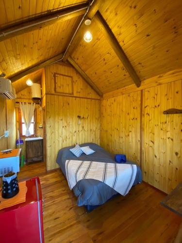 ビージャ・セラニタにあるCUYEN LA SERRANITA Dormi DLX Cabin para 2 Personasの木製の部屋にベッド1台が備わるベッドルーム1室があります。