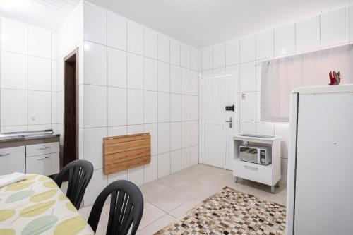 a white kitchen with a refrigerator and a stove at 07 Residencial Lazzaris ap a poucos metros do parque in Penha