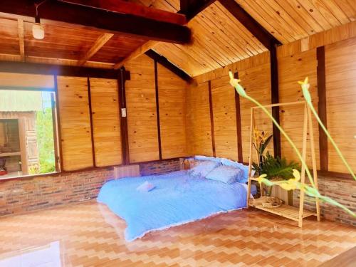 a large bed in a room with wooden walls at Nhà Bên Hồ 2- The Peace's House in Ấp Thánh Hương