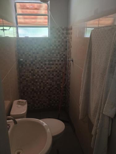 ein kleines Badezimmer mit Waschbecken und Toilette in der Unterkunft Chácara Cachoeira in Socorro