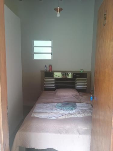 Bett in einem kleinen Zimmer mit Fenster in der Unterkunft Chácara Cachoeira in Socorro