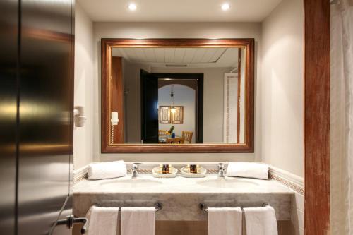 a bathroom with a sink and a mirror at Apartahotel Suites Vila Birdie in Navata