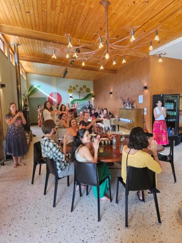 a group of people sitting around a table in a room at Espaço Canto in Santo Antônio do Pinhal