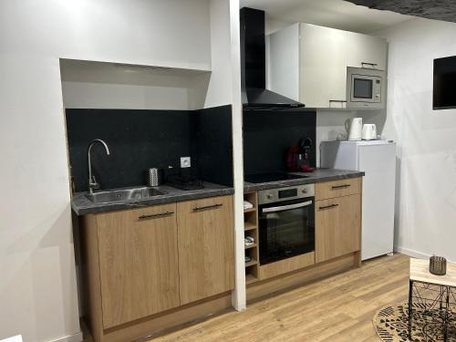 une petite cuisine avec un évier et un réfrigérateur dans l'établissement L' Urbain- Centre ville - Climatisé, à Montluçon