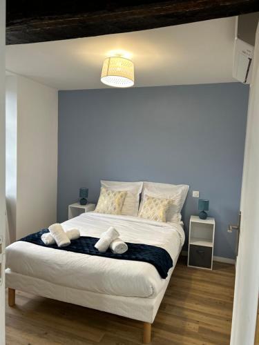 une chambre avec un lit avec deux animaux en peluche dessus dans l'établissement L' Urbain- Centre ville - Climatisé, à Montluçon