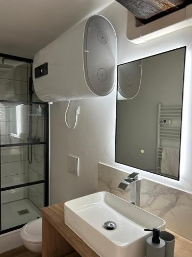 une salle de bain avec un lavabo et un miroir et des toilettes dans l'établissement L' Urbain- Centre ville - Climatisé, à Montluçon