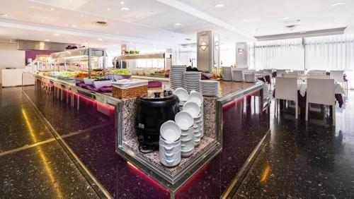 a buffet line in a hotel with plates and dishes at Globales Palmanova in Palmanova