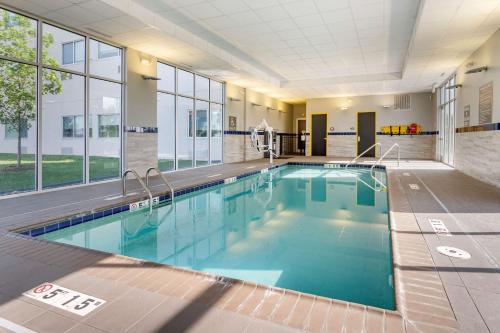a pool with blue water in a building with windows at GLō Best Western Lexington in Lexington