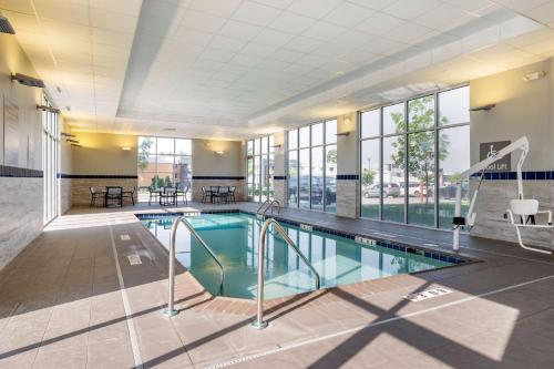 a large swimming pool in a building with a large window at GLō Best Western Lexington in Lexington