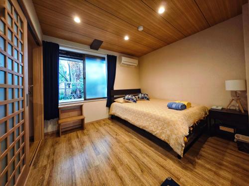 a bedroom with a bed and a large window at 3BR Private House with Open-air Bath & garden, 5min to subway! 柚苑YUEN in Osaka