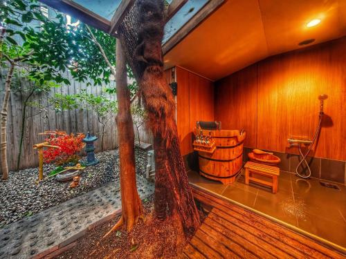 a tree in the middle of a room with a barrel at 3BR Private House with Open-air Bath & garden, 5min to subway! 柚苑YUEN in Osaka