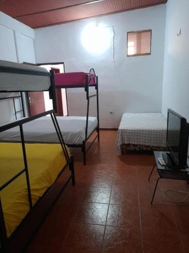 a room with two bunk beds and a tv at Donde Rafa in Maracay