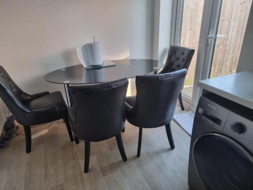 a dining room table with chairs and a table with a candle at Charming Modern Home in Cheltenham in Cheltenham