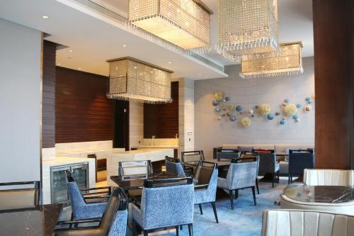 a dining room with tables and chairs and chandeliers at Anyang Wanda Realm Hotel in Anyang