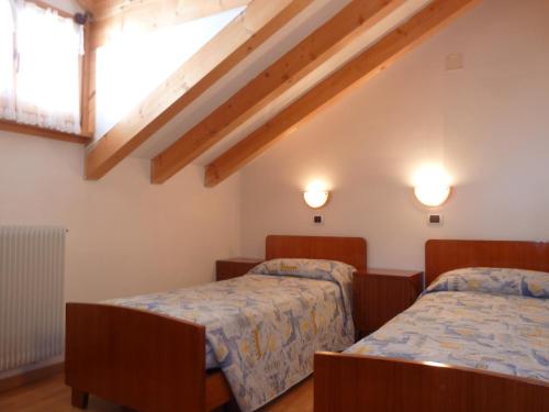 - une chambre avec 2 lits et une fenêtre dans l'établissement Casa Frizzera, à Molveno