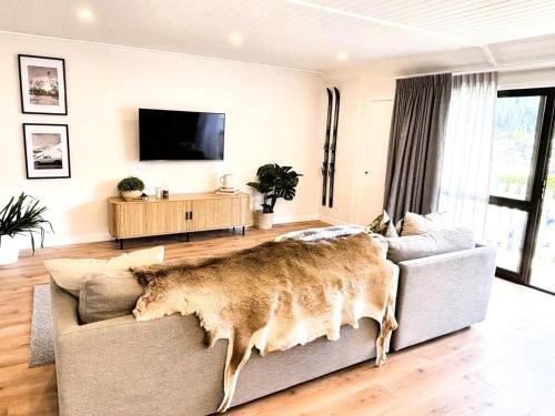 a living room with a couch and a tv at Central City Queenstown Retreat - 3 Bedroom Apartment in Queenstown