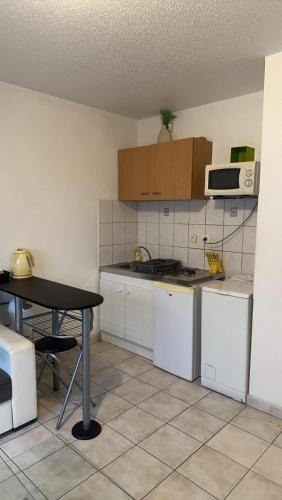 une petite cuisine avec une table et un micro-ondes dans l'établissement Studio meublé, à Mulhouse