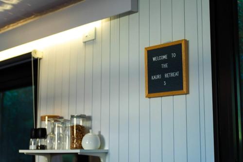 a chalk board on a wall with a sign on it at The Kauri Haven by Tiny Away in Waitoki