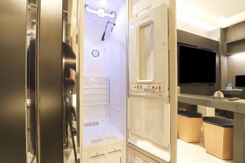 a small kitchen with a refrigerator in a room at Hotel OSCAR in Daegu
