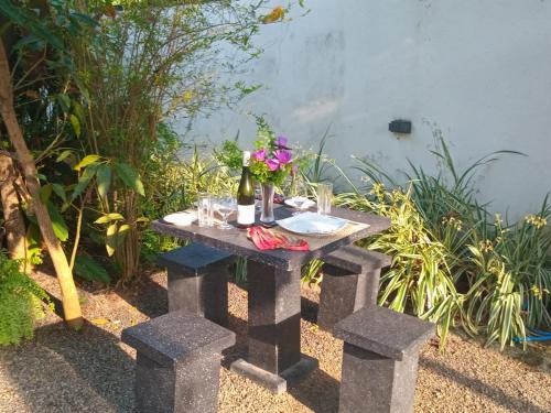 a picnic table with two bottles of wine and flowers on it at Villa Sol in Kamburugamuwa
