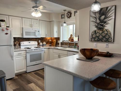 a kitchen with white cabinets and a counter top at Boutique Beachside condo with easy access to beach in Saint Augustine