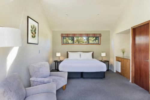 a hotel room with a bed and two chairs at Edit Hanmer Springs in Hanmer Springs